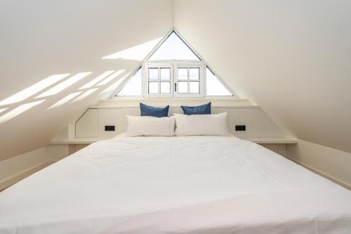 a bedroom with a white bed with blue pillows at Haus Marit in Westerland