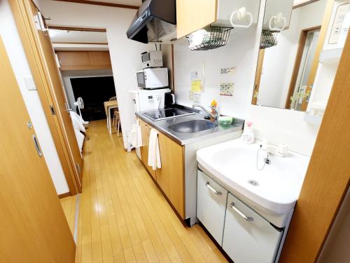 a small kitchen with a sink and a microwave at Takaraboshi room 201 Sannomiya 10 min in Kobe