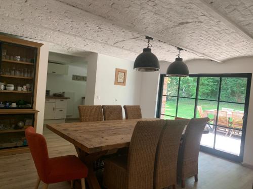 une salle à manger avec une table et des chaises en bois dans l'établissement Etable rénovée 10 mn Lille, à Englos
