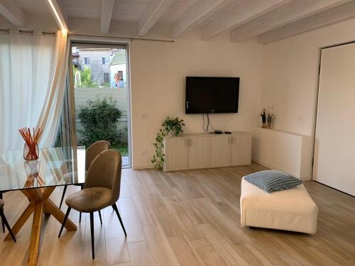 a living room with a table and a flat screen tv at Appartamento GARDA in Padenghe sul Garda