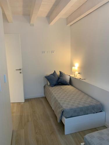 a bedroom with a bed in a white room at Appartamento GARDA in Padenghe sul Garda