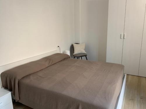 a bedroom with a bed and a chair at Appartamento GARDA in Padenghe sul Garda