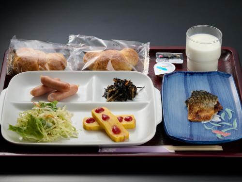 un vassoio con un piatto di cibo e un bicchiere di latte di Hotel ST MORITZ a Yuzawa