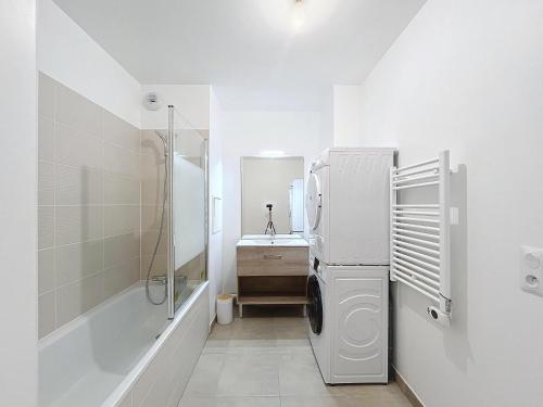 La salle de bains blanche est pourvue d'un évier et d'un réfrigérateur. dans l'établissement Le Bleuet - Proche Paris - 2 BDR - Terrasse, à Bezons