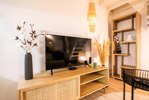 - un salon avec une télévision à écran plat dans un centre de divertissement en bois dans l'établissement Le St Jean - 26m2 Vieux Lyon, à Lyon