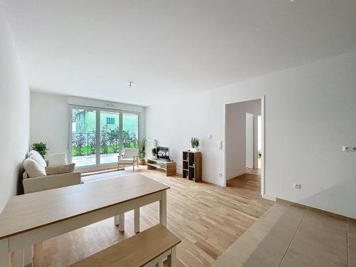 - un salon vide avec une table et un canapé dans l'établissement Le Bleuet - Proche Paris - 2 BDR - Terrasse, à Bezons