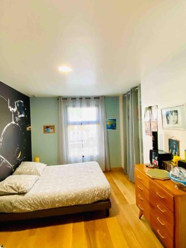 une chambre avec un lit, une commode et une fenêtre dans l'établissement Maison avec piscine à 10 min du centre de Bordeaux, à Bègles