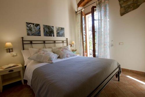 a bedroom with a large bed and a window at Il Bottaccio Casa di Campagna in Venturina Terme