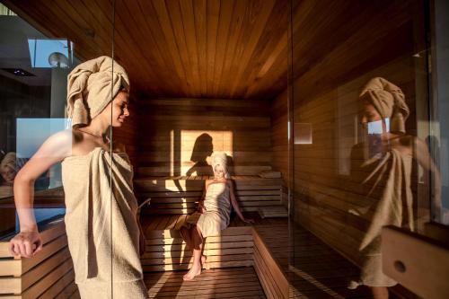 a woman in a sauna with a girl sitting in it at Palazzo Loup Hotel in Loiano