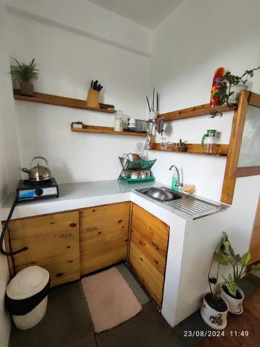 a kitchen with a sink and wooden cabinets and shelves at Tanay Private Staycation house in Tanay
