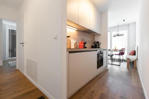 a kitchen with white cabinets and a dining room at Arton Lachtal - Apartments Steiermark in Lachtal