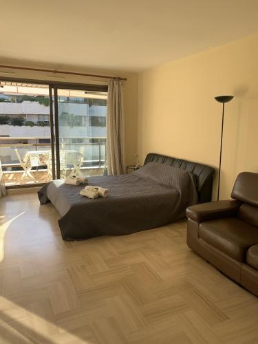 une chambre avec un lit, un canapé et une fenêtre dans l'établissement Gray d'Albion POL519 studio, à Cannes