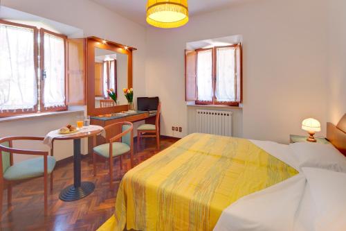 a bedroom with a bed and a table and a desk at Affittacamere Villa Gigli in Sirolo