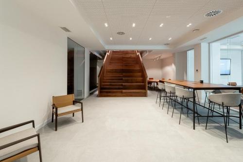 a room with a staircase and a table and chairs at Apartamentos 2H LIVING in León