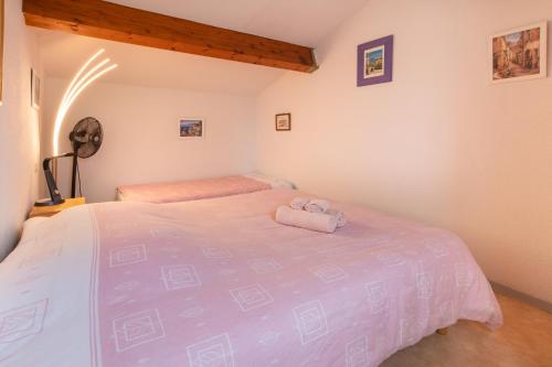 a bedroom with a bed with a stuffed animal on it at Le Moulin Maison Internet WiFi Parking Terrasse Résidence avec Piscine in Portiragnes