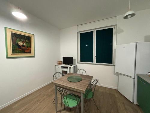 a small kitchen with a table and a refrigerator at Come a Casa in Vittuone