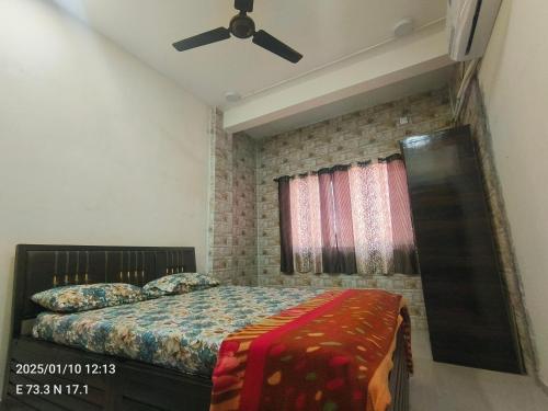 a bedroom with a bed and a ceiling fan at Ojas Villa - 2BHK Villa at Ganpatipule in Ganpatipule