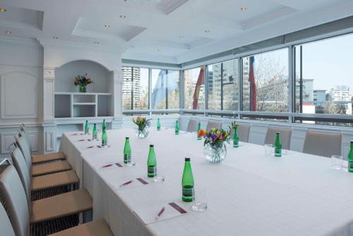 a large conference room with a long table with green bottles at NH Collection Plaza Santiago in Santiago