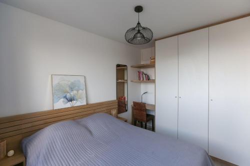 - une chambre avec un lit, des armoires blanches et un bureau dans l'établissement Nice 3 rooms with balcony in Pré-Saint-Gervais, à Le Pré-Saint-Gervais