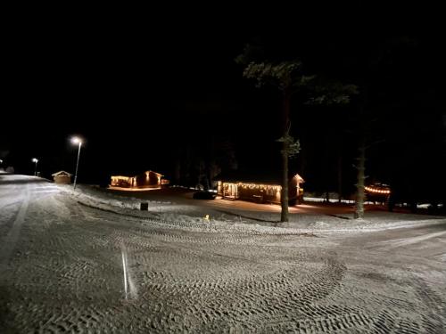 a snow covered street at night with lights at Kiiski Home in Teijo