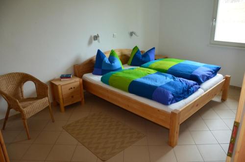 a bedroom with a bed with blue and green pillows at FerienhausLychen in Lychen