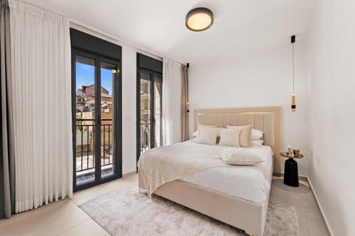 une chambre blanche avec un lit et un balcon dans l'établissement Luxury 3 BDR In The Heart Of Jerusalem By Isrentals, à Jérusalem