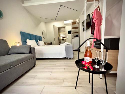 a living room with a bed and a table with wine glasses at PORTO PORTES suites in Nea Potidaea