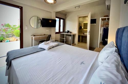 a bedroom with a large bed with towels on it at PORTO PORTES suites in Nea Potidaea