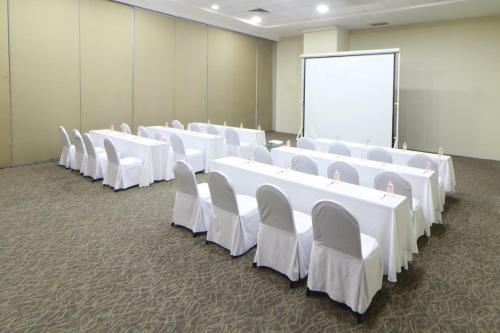 a conference room with white tables and chairs and a screen at Holiday Inn Express Ciudad Del Carmen by IHG in Ciudad del Carmen
