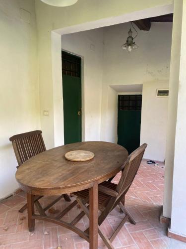 a wooden table and chairs in a room with green doors at Casale Monte Oliviero - Bike Friendly B&B in Rome