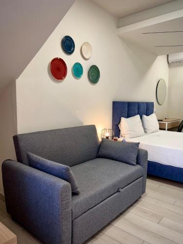 a living room with a couch and a bed at PORTO PORTES suites in Nea Potidaea