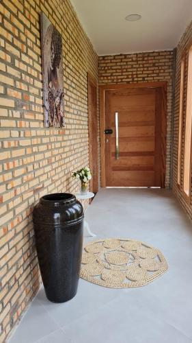 a large black vase sitting in front of a door at Chalé condensa in Fortaleza