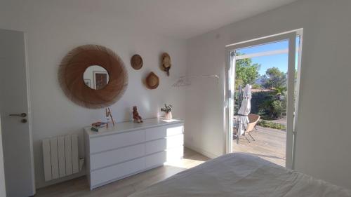 - une chambre blanche avec une commode et un miroir dans l'établissement Maison au cœur du Var, à Sillans-la-Cascade