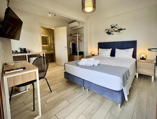 a hotel room with a bed and a desk and a bed at PORTO PORTES suites in Nea Potidaea