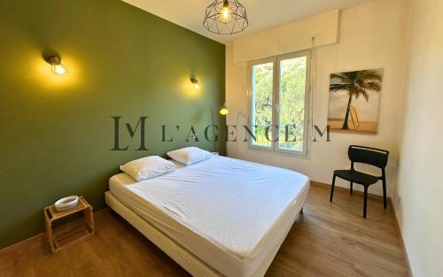 - une chambre verte avec un lit et une chaise dans l'établissement Appartement Alivi Proche centre-ville & paisible L'ILE-ROUSSE, à LʼÎle-Rousse
