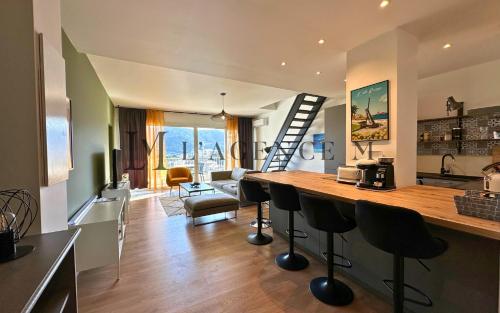 une cuisine et un salon avec un comptoir et des chaises dans l'établissement Appartement Alivi Proche centre-ville & paisible L'ILE-ROUSSE, à LʼÎle-Rousse
