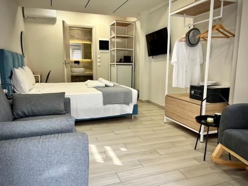 a hotel room with a bed and a living room at PORTO PORTES suites in Nea Potidaea