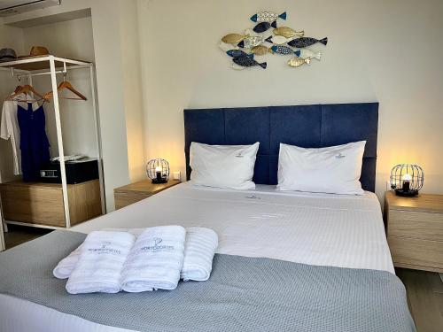 a bedroom with a bed with two towels on it at PORTO PORTES suites in Nea Potidaea