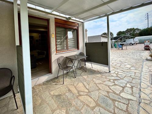 a patio with a table and chairs on a building at PORTO PORTES suites in Nea Potidaea