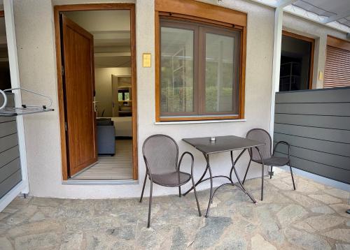 a table and chairs sitting outside of a house at PORTO PORTES suites in Nea Potidaea