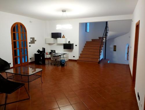 a living room with a wooden floor and a staircase at Villa Le Arcate in Corleto Perticara