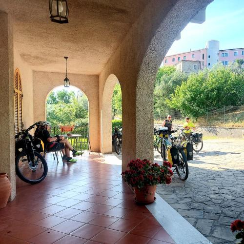 a group of people sitting in a patio with bikes at Villa Le Arcate in Corleto Perticara