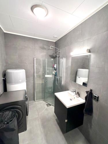 a bathroom with a shower and a sink and a mirror at Kolsåsbakken, Granåsen, Nordic Ski World Championships in Trondheim