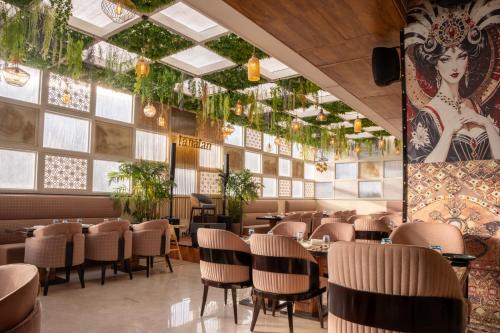 a restaurant with tables and chairs and a large wall of windows at Ramee Tarang Hotel Indore in Indore