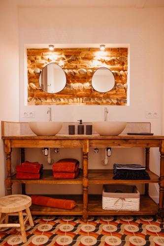 une salle de bain avec deux lavabos et deux miroirs dans l'établissement Maison arcades suite 1, à Verdun-sur-Garonne