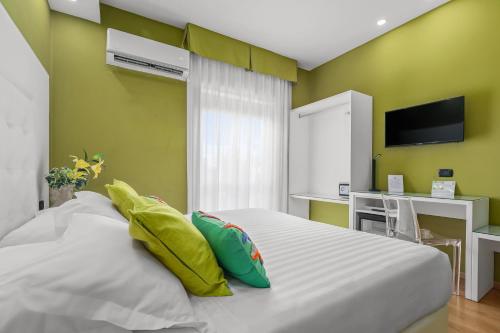 a bedroom with a white bed with green walls at Reggia Suite Spa Hotel in Caserta