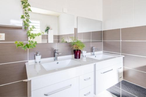 a bathroom with two sinks and a mirror at La Kaz Isle Bourbon in Saint-Pierre