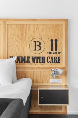 a bedroom with a bed and a table with a sign at B's Strandappartementen in Domburg