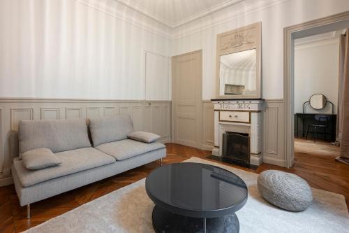 un salon avec un canapé et une table dans l'établissement Appartement Élégant et Spacieux dans le 8ème, à Paris
