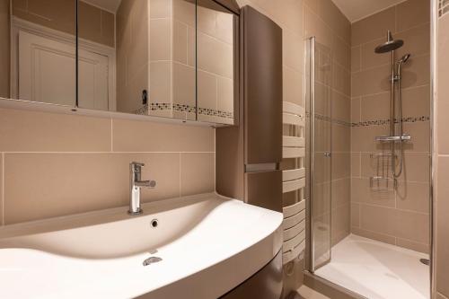 une salle de bain avec un lavabo et une douche dans l'établissement Appartement Élégant et Spacieux dans le 8ème, à Paris